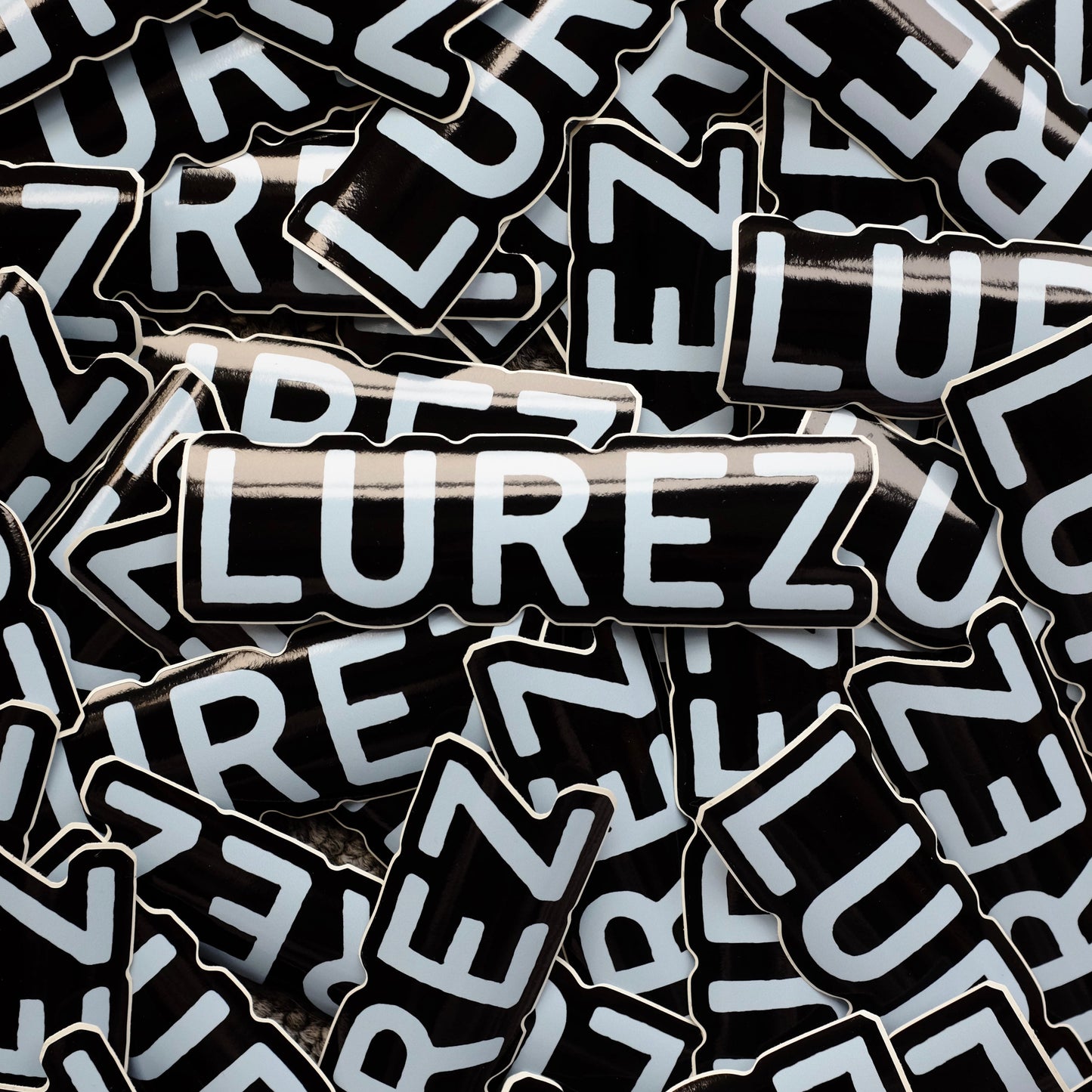 Stack of black and white 'LUREZ' branded stickers.