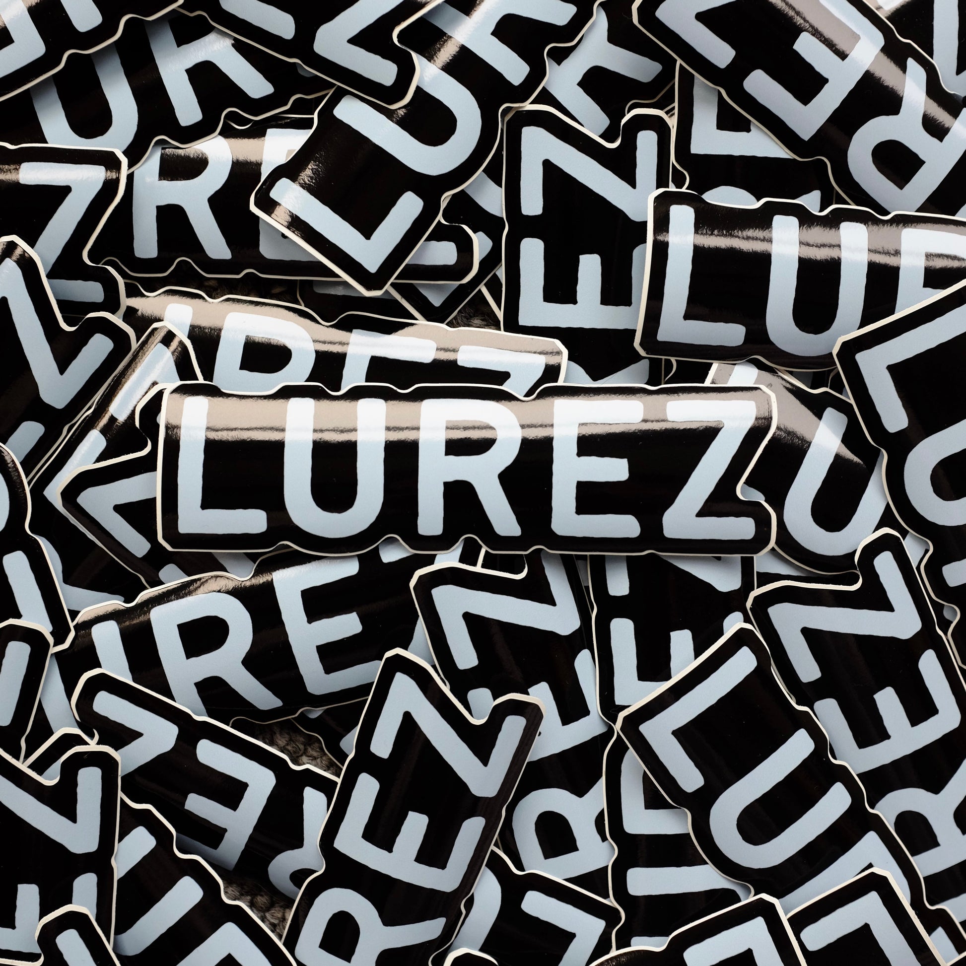 Stack of black and white 'LUREZ' branded stickers.