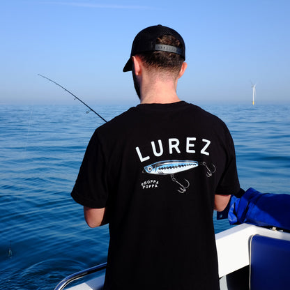 Person wearing a black hoodie with 'LUREZ' branding on a boat.